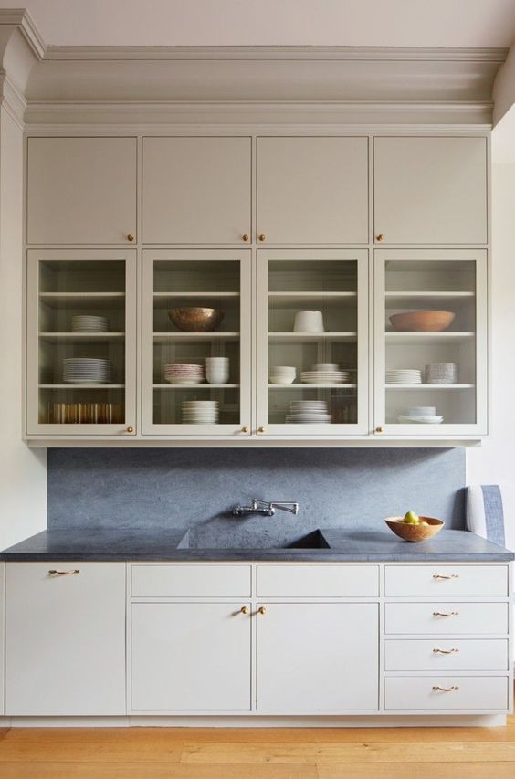 Majestic Cabinet | a kitchen with glass front cabinet, white color, dark counter top